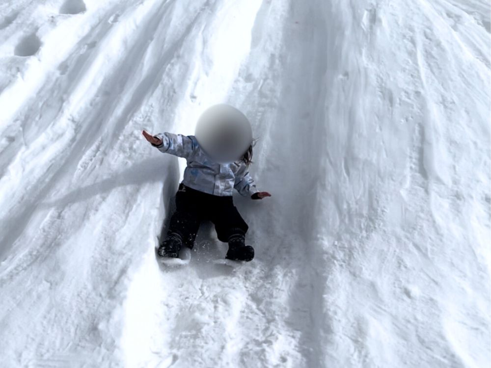 雪山から滑り降りる子供